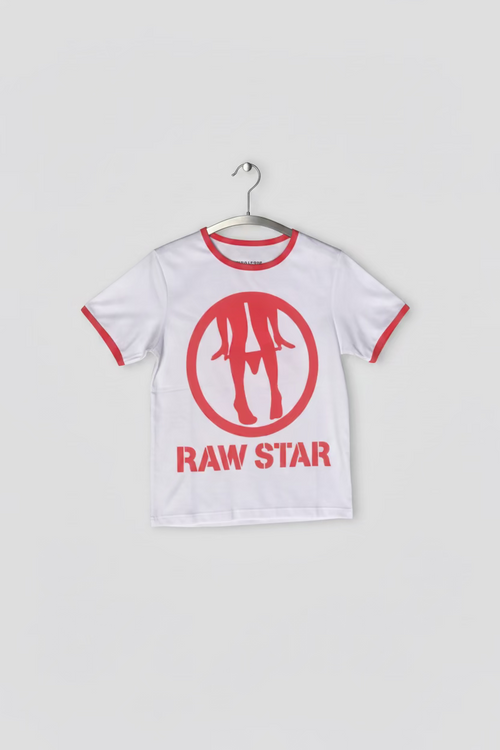 A white short-sleeve t-shirt with red trim on the collar and sleeve cuffs, featuring a red circular logo with three stylized figures and the text 'RAW STAR' printed vertically on the front. The shirt is laid flat on green grass.