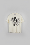 An off-white distressed t-shirt hanging on a hanger, featuring a black graphic print of a woman with a sword surrounded by a spider and web, next to a white t-shirt.